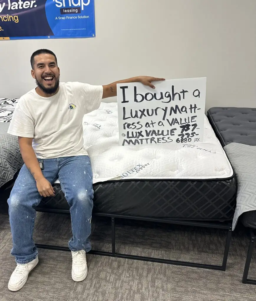 Satisfied buyer showing off discounted hybrid mattress deal from Lux Value